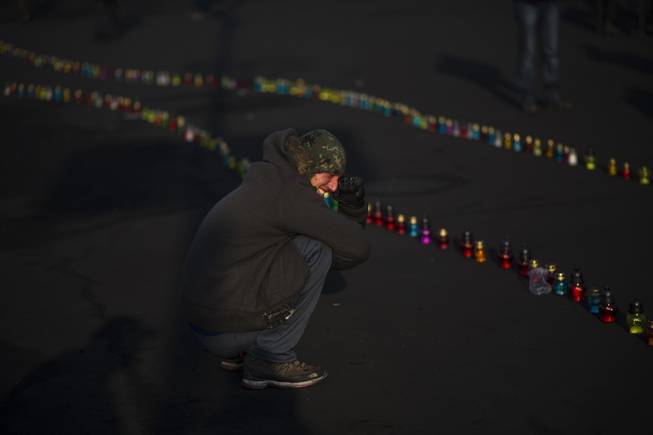 An opposition supporter cries near to a memorial for the people killed in clashes with the police at Independence Square in Kiev, Ukraine, Monday, Feb. 24, 2014. 