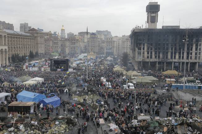 General view of Kiev's Independence Square, the epicenter of the country's recent unrest, Ukraine, on a mourning day  Sunday, Feb. 23, 2014. Official reports say 82 person were killed in severe clashes between opposition activists and riot police. A destroyed trade union house which was burned in clashes seen in the background right. 