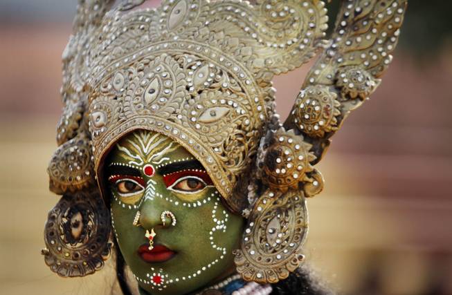 A women dressed as Hindu Goddess Kali participates in a procession on the eve of Shivratri festival, in Jammu, India, Wednesday, Feb. 26, 2014. 