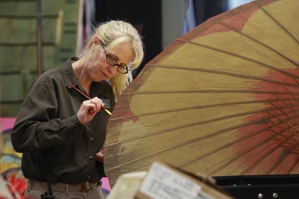 Susie French paints a parasol for the spring display in the storage area for the Bellagio's Conservatory and Botanical Gardens Feb. 28, 2014.