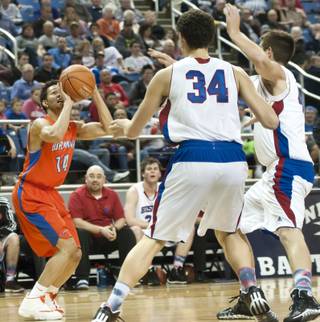 Noah Robotham pulls up for a fading jumper in the eyes of two defenders Thursday, Feb. 27, 2014 as Bishop Gorman defeats Reno 68-27 in the semifinals of the Nevada State Championships at Lawlor Events Center in Reno.