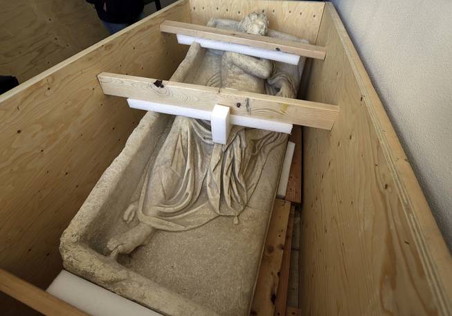 An ancient Roman sculpture seized at a warehouse by Homeland Security investigators in the Queens borough of New York, Friday, is crated in the back of a truck, Feb. 28, 2014. 