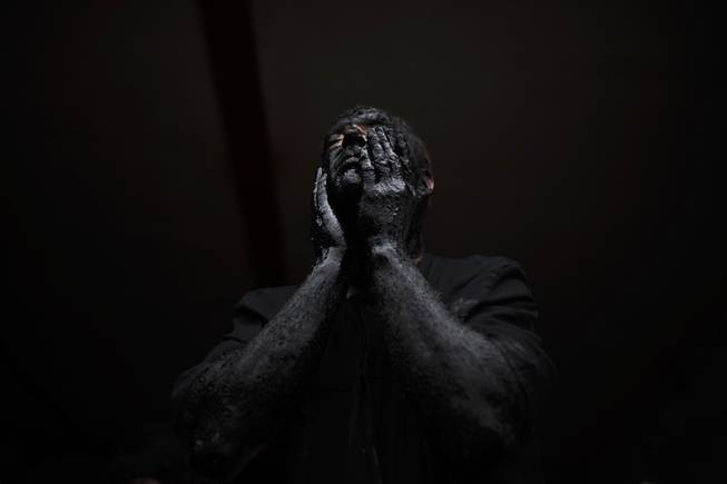 A man covers his face in oil and soot as he gets ready to start the carnival festival in the small village of Luzon, Spain, Saturday, March 1, 2014. Preserved records from the 14th century document Luzon's carnival, but the real origin of the tradition could be much older. Carnival festivals are celebrated in their own way around hundreds of villages in Spain. 
