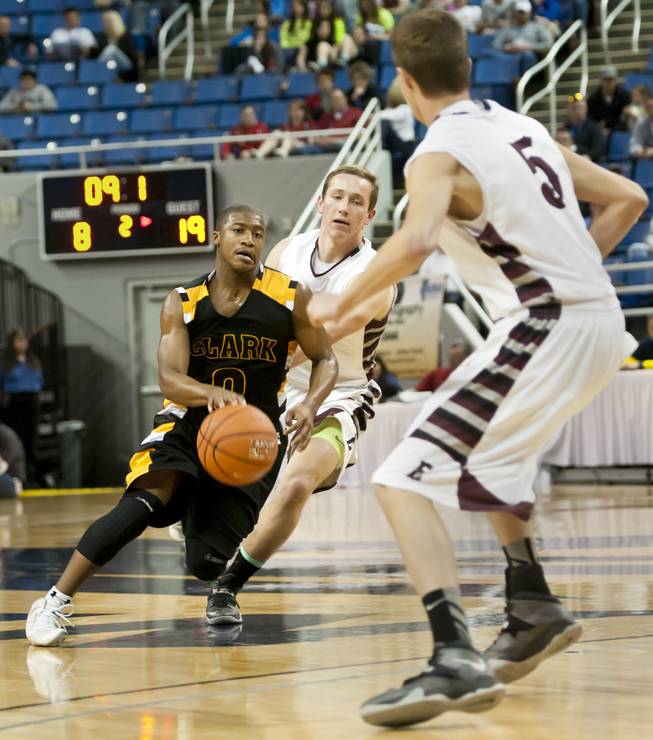 Colby Jackson gets between two defenders before dumping the ball off to a teammate for a score Saturday, March 1, 2014 as Clark High School defeated Elko High School 43-25 winning the Division I-A state championship at Lawlor Event Center in Reno.
