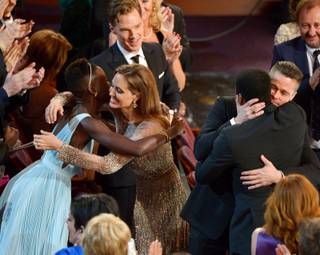 Lupita Nyong'o, left, is embraced by Angelina Jolie, and Brad Pitt embraces Chiwetel Ejiofor as they celebrate in the audience after 