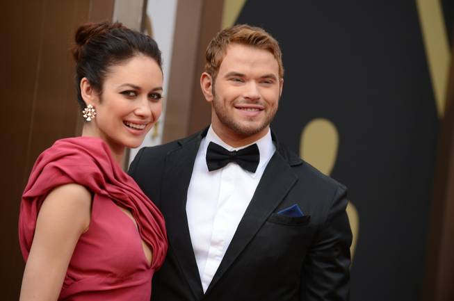 Olga Kurylenko, left, and Kellan Lutz arrive at the Oscars on Sunday, March 2, 2014, at the Dolby Theatre in Los Angeles.  (Photo by Jordan Strauss/Invision/AP)