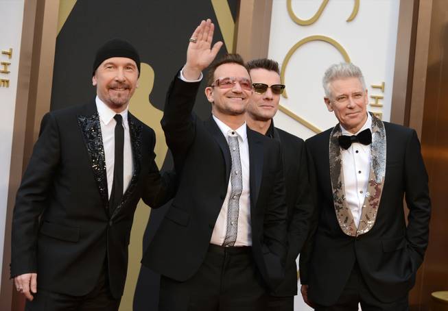 The Edge, from left, Bono, Larry Mullen, Jr., and Adam Clayton of U2 arrive at the Oscars on Sunday, March 2, 2014, at the Dolby Theatre in Los Angeles.  (Photo by Jordan Strauss/Invision/AP)