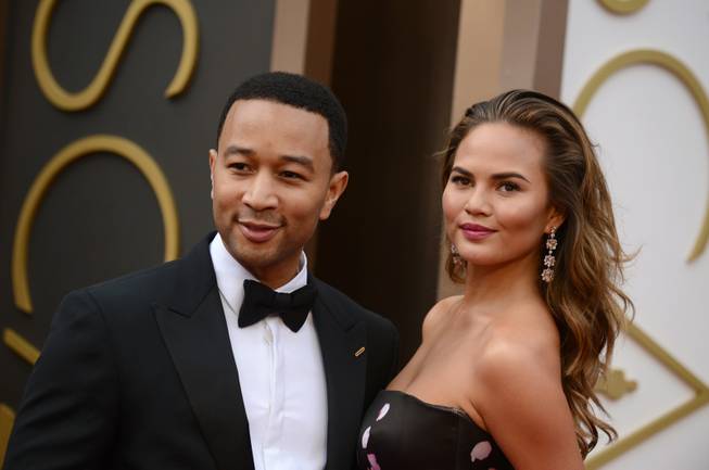 John Legend and Chrissy Teigen arrive at the Oscars on Sunday, March 2, 2014, at the Dolby Theater in Los Angeles.