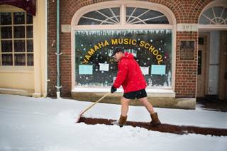 Owner of Bodywork Wayne Gootee shovels the walkway in front of businesses in Fredericksburg, Va during the snowstorm on Monday, March 3, 2014. 