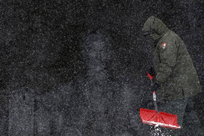 National Park Service employee Eric Tolliver shovels snow and ice at the Lincoln Memorial as snow falls in Washington, Monday, March 3, 2014.