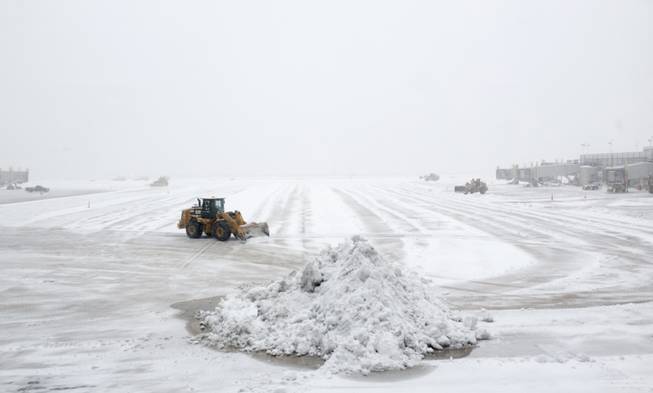 Workers clear the tarmac of snow so that flights can resume at Washington's Ronald Reagan National Airport, Monday, March 3, 2014. 