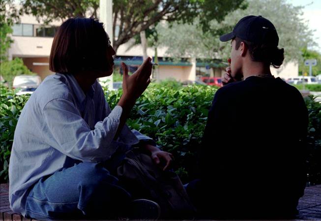In this file photo, two unidentified high school students smoke a cigarette after class at a shopping center near their school in Miami. In Nevada, a survey of high school students found that 38 percent had smoked a cigarette. The survey also revealed teen behavior regarding sex, alcohol use and marijuana use, among other things.
