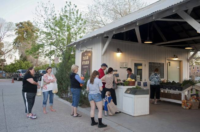 Customers at Agritopia's Farm Stand market, which overlooks the fields and is the hub of the community, in Gilbert, Ariz., March 5, 2014. A growing number of residential developments, known as agrihoods, are designed around a working farm instead of a golf course or clubhouse.