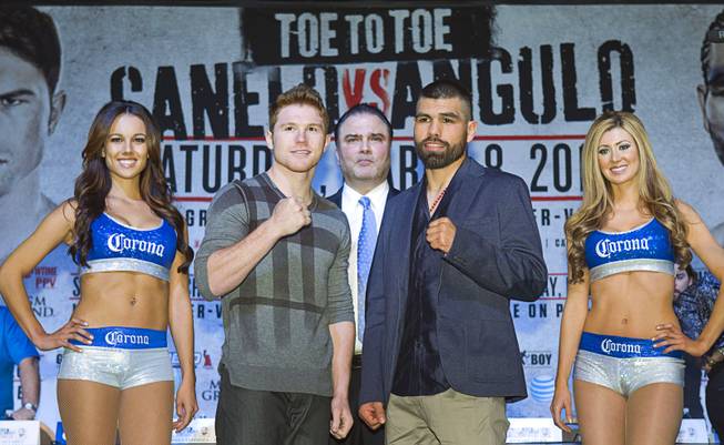 Super welterweight boxers Canelo Alvarez, left, and Alfredo Angulo face off during a news conference at the MGM Grand Thursday, March 6, 2014. Richard Schaefer, CEO of Golden Boy Promotions, looks on at center. Alvarez and Angulo, both of Mexico, will fight at the MGM Grand Garden Arena on Saturday.