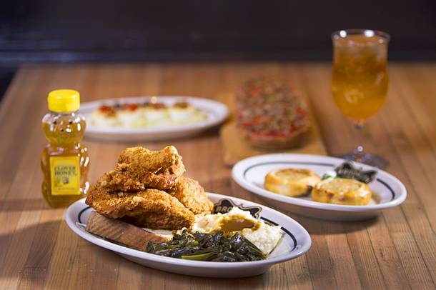 A Fried Chicken Dinner served with bread, honey, collard greens and mashed potatoes at the Brooklyn Bowl in the Linq Thursday, March 6, 2014. Also pictured are Egg Shooters, Potato and Onion Knish and San Gennaro Pizza.