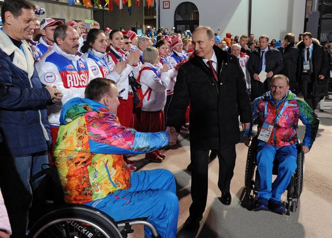 In this photo taken Thursday, March 6, 2014, Russian President Vladimir Putin, center, greets athletes during his visit to the mountain Paralympic village in Krasnaya Polyana, Russia, on the eve of the opening ceremony of the 2014 Winter Paralympics in Sochi. At right is Sergei Shilov, six time Paralympic Champion.