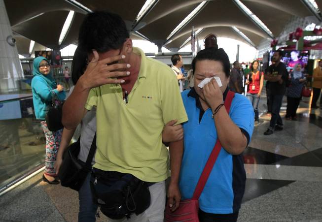A woman wipes her tears after walking out of the reception center and holding area for family and friends of passengers aboard a missing Malaysia Airlines plane at Kuala Lumpur International Airport in Sepang, Malaysia, on Saturday, March 8, 2014. 