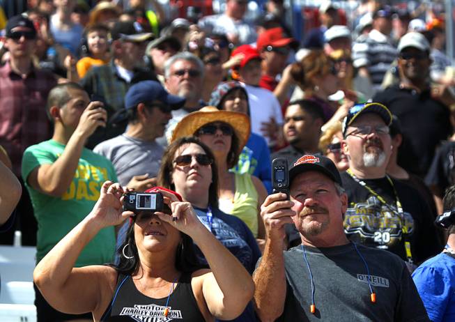 A couple takes video on their phones during the Kobalt 400 NASCAR Sprint Cup Series race at the Las Vegas Motor Speedway Sunday, March 9, 2014.