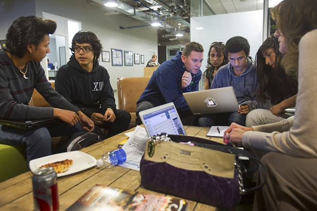 Mentor Fred Guest, center, of Zappos, helps high school students as they huddle over laptops during a workshop for first annual Congressional Science, Technology, Engineering and Math (STEM) Academic Competition, also known as the House App Contest, at Zappos in downtown Las Vegas Monday, March 10, 2014. The national contest for high school students, established by members of the U.S. House of Representatives in 2013, involves developing an app and creating a video demonstration to explain it.