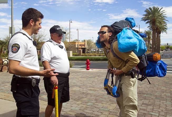 The District security officers Atom Fogarty , left, and Carl Knoll talk with Robert Sorensen, 27, as he heads out for a walk from Henderson to Israel Monday, March 10, 2014. Sorensen said he is not a religious man but that it was a "spiritual" journey. Sorensen estimated the trip to be 16,500 miles.