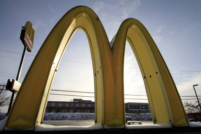 In this Tuesday, Jan. 21, 2014, file photo, the McDonald's Golden Arches logo at a McDonald's restaurant is covered with snow in Robinson Township, Pa.
