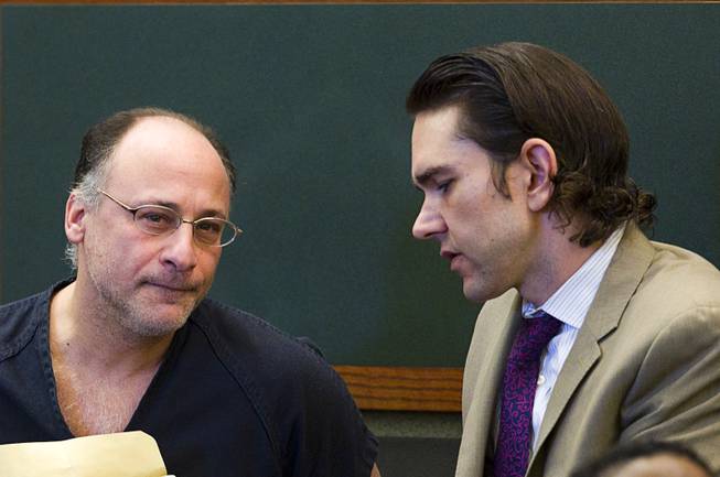 Mark Picozzi, left, listens to attorney Casey Landis before his  preliminary hearing at the Regional Justice Center Tuesday, March 11, 2014. Picozzi is accused of impersonating a police officer and forcing women working for escort services to perform sexual acts.