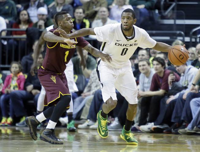 Oregon forward Mike Moser, right, dribbles against Arizona State guard Jahii Carson during the second half of an NCAA college basketball game in Eugene, Ore., Tuesday, March 4, 2014.  Moser led Oregon with 22 points and 17 rebounds as they beat Arizona State 85-78.