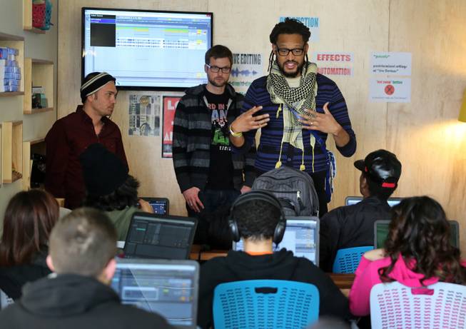 In this Monday, Feb. 10, 2014, photo, members of The Flobots and Youth on Record founders James Laurie, center, and Stephen Brackett, right, work with music students at Youth on Record headquarters in Denver. 