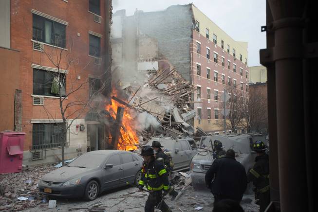 Firefighters work the scene of an explosion and building collapse in the East Harlem neighborhood of New York, Wednesday, March 12, 2014. The explosion leveled an apartment building, and sent flames and billowing black smoke above the skyline.