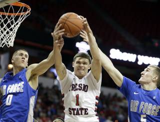Air Force's Marek Olesinski, left, and Zach Kocur, right try to bring down a rebound with Fresno State's Tyler Johnson during the second half of a Mountain West Conference tournament NCAA college basketball game Wednesday, March 12, 2014, in Las Vegas. Fresno State defeated Air Force 61-59. (AP Photo/Isaac Brekken)