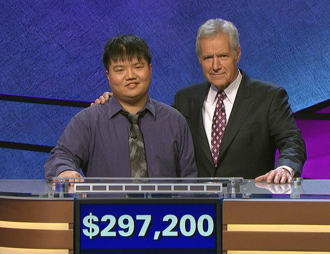 Contestant Arthur Chu and host Alex Trebek stand with a total of Chu’s winnings at a taping of “Jeopardy!” in Culver City, Calif. 