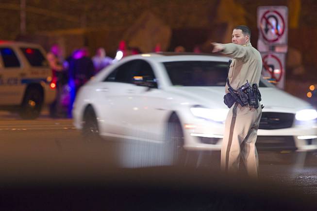 A Metro Police offer directs traffic after a shooting victim was involved in an accident at the 1-215 eastbound off-ramp at Eastern Avenue Thursday, March 13, 2014. The driver, who had been shot multiple times, may have been shot at another location, police said.