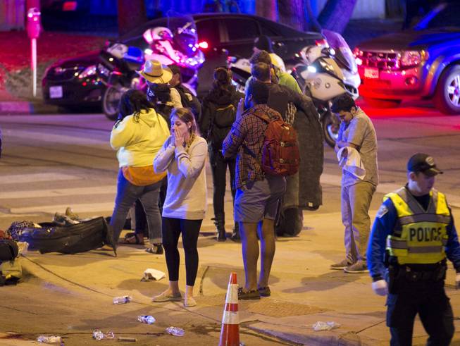 Bystanders react after several people were struck by a vehicle on Red River Street in downtown Austin, Texas, at SXSW on Wednesday March 12, 2014. Police say two people were confirmed dead at the scene after a car drove through temporary barricades set up for the South By Southwest festival and struck a crowd of pedestrians.