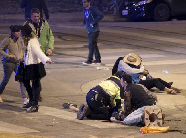 People perform CPR on a woman after she was struck by a vehicle on Red River Street in downtown Austin, Texas, at SXSW on Wednesday March 12, 2014. Police say a man and woman have been killed after a suspected drunken driver fleeing from arrest crashed through barricades set up for the South By Southwest festival and struck the pair and others on a crowded street.