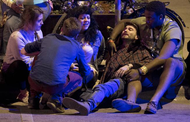 Unidentified people are comforted after being struck by a vehicle on Red River Street in downtown Austin, Texas, during SXSW on Wednesday March 12, 2014. Police say two people were confirmed dead at the scene after a car drove through temporary barricades set up for the South By Southwest festival and struck a crowd of pedestrians.
