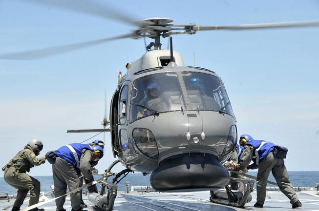 In this photo released by the Royal Malaysian Navy, a Fennec helicopter prepares to depart to aid in the search and rescue efforts for the missing Malaysia Airlines plane over the Straits of Malacca, Malaysia, Thursday, March 13, 2014.