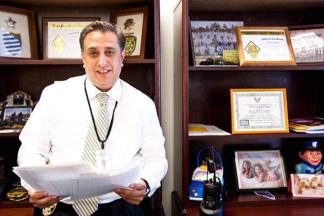 Surrounded by appreciation certificates and high school team photos, Detective Thomas Rainey, with the Clark County School District Police Department, smiles while reading thank-you letters he received from previously graduated students of Bonanza High School while working in his office at the CCSD Police Department Friday, March 7, 2014.