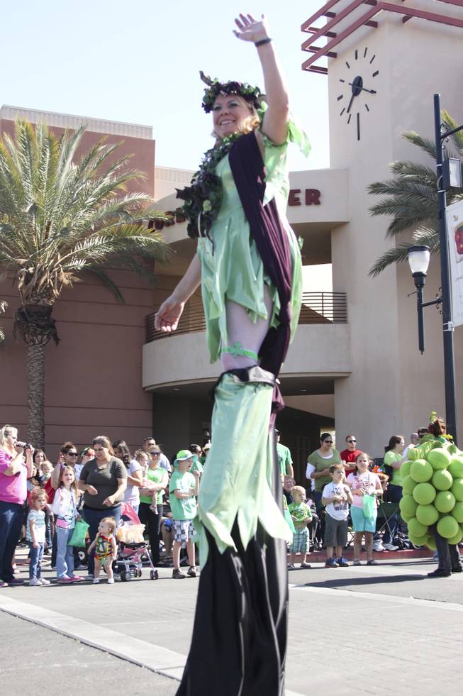 A participant on stilts waves to the crowd during the annual St. Patrick's Day parade in Henderson Saturday, March 15, 2014.