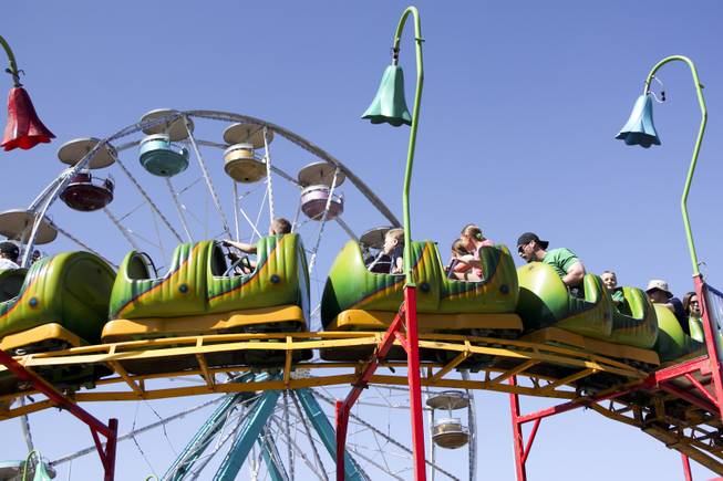 Carnival goers enjoy a roller coaster ride during the annual St. Patrick's Day parade in Henderson Saturday, March 15, 2014.