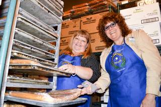 Misti Gower, left, and Heidi Englund check the cakes that will be used to make the state's 150th anniversary cake. It will measure 21 feet long by 13 feet wide and be in the shape of the state.