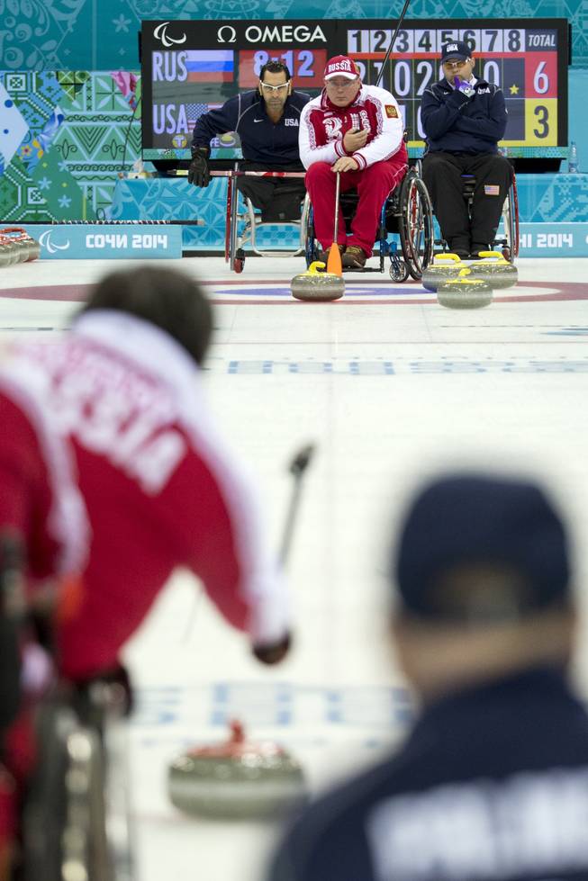 Russia's Andrey Smirnov, top center, lines up a shot during wheelchair curling match between United States and Russia at the 2014 Winter Paralympics in Sochi, Russia, Monday, March 10, 2014. Russia won 6-5.
