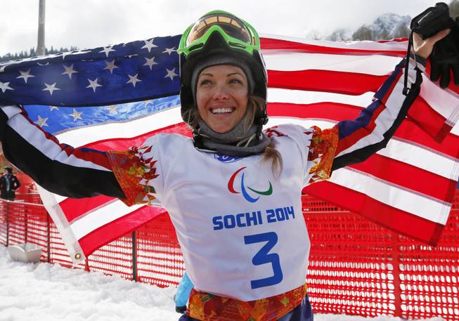 Amy Purdy of the United States celebrates her third-place finish in the women's para snowboard cross standing event at the 2014 Winter Paralympic, Friday, March 14, 2014, in Krasnaya Polyana, Russia. 
