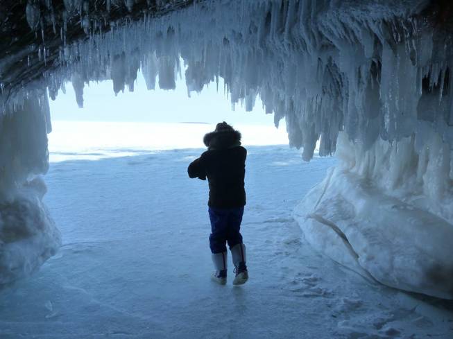 Patti Heil visits caves covered in ice along Lake Superior near Cornucopia, Minn. A deep freeze this winter has made it so people can walk across the frozen lake and look at the natural ice formations, but it has also hindered shipping in the region.