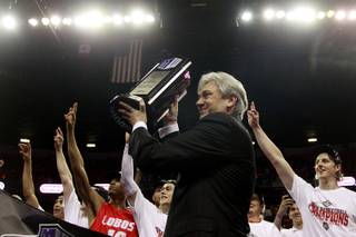 New Mexico coach Craig Neal hoists their trophy after defeating San Diego State 64-58 in their Mountain West Conference tournament championship game Saturday, March 15, 2014 at the Thomas & Mack Center.