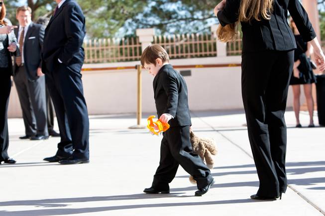 Toting a comforting teddy bear, Michael James Gaughn, 3, walks toward the sanctuary for the memorial mass for his grandfather, John Davis "Jackie" Gaughan, at St. Viator Catholic Church in Las Vegas on St. Patrick's Day, March 17, 2014.