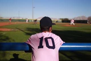 A Canyon Springs player watches from the dugout  during their game against Western Wednesday, March 19, 2014. The Pioneers wore pink jerseys for the game for cancer awareness and to honor parents of two of the players who died from cancer in the past year.