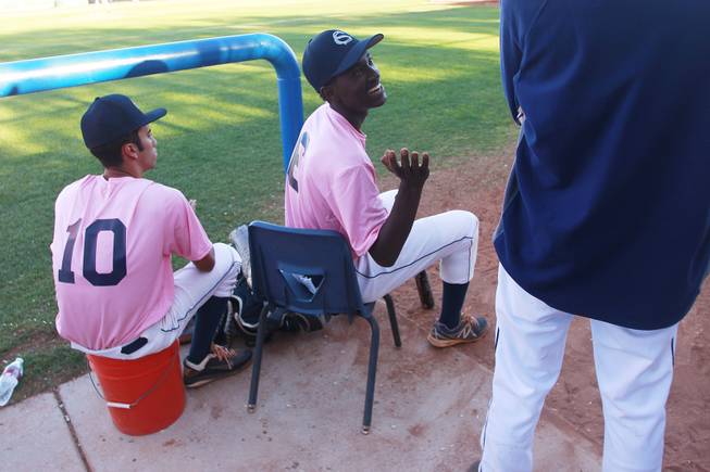 Canyon Springs outfielder Rashaad Jones jokes with a coach during their game against Western Wednesday, March 19, 2014. The Pioneers wore pink jerseys for the game for cancer awareness and to honor parents of two of the players who died from cancer in the past year.