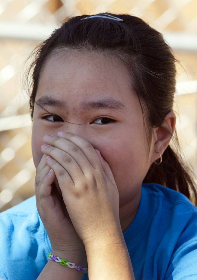 A Joseph E. Thiriot Elementary School student holds her nose with the small of manure in the air from their new edible garden on Wednesday, March 19, 2014.