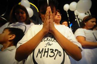 A young Malaysian boy prays, at an event for the missing Malaysia Airline, MH370, at a shopping mall, in Petaling Jaya,  on the outskirts of Kuala Lumpur, Malaysia, Tuesday, March 18, 2014.  