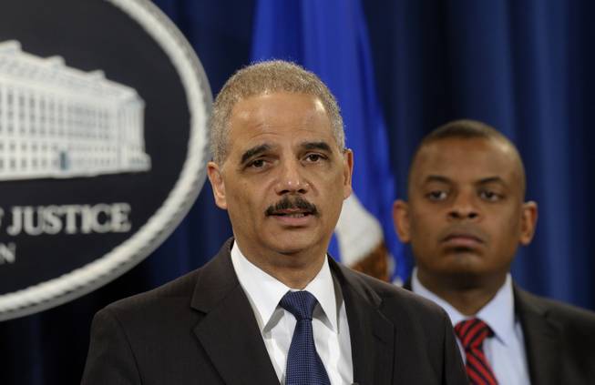 Attorney General Eric Holder, left, accompanied by Transportation Secretary Anthony Foxx, announces a $1.2 billion settlement with Toyota over its disclosure of safety problems, Wednesday, March 19, 2014, during a news conference at the Justice Department in Washington.
